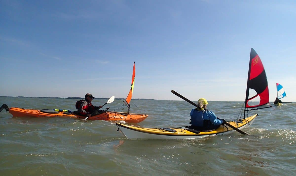 two kayaks with sail in open sea