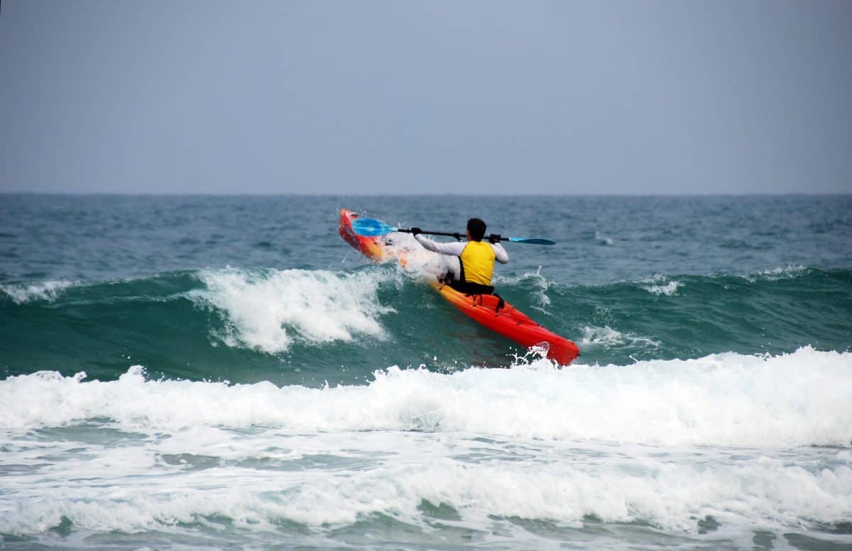 sea kayaker paddles towards to a wave 