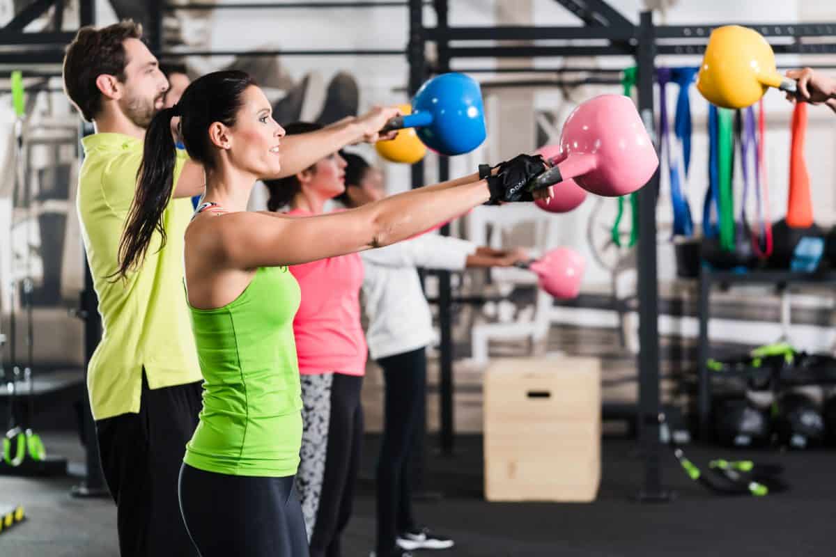 Functional fitness workout in sport gym with kettlebell swings