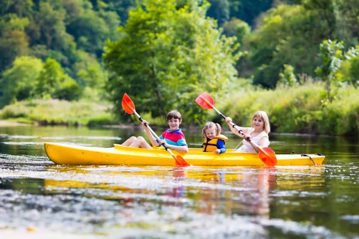 Family of three in bright yellow kayak