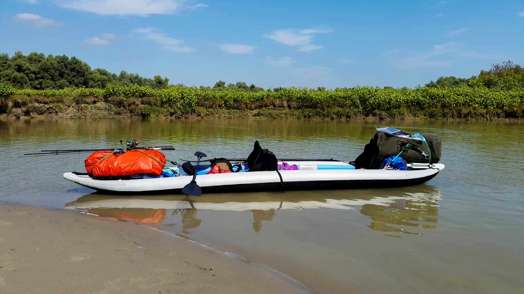 A double person inflatable kayak equipped for touring in a sunny summer 