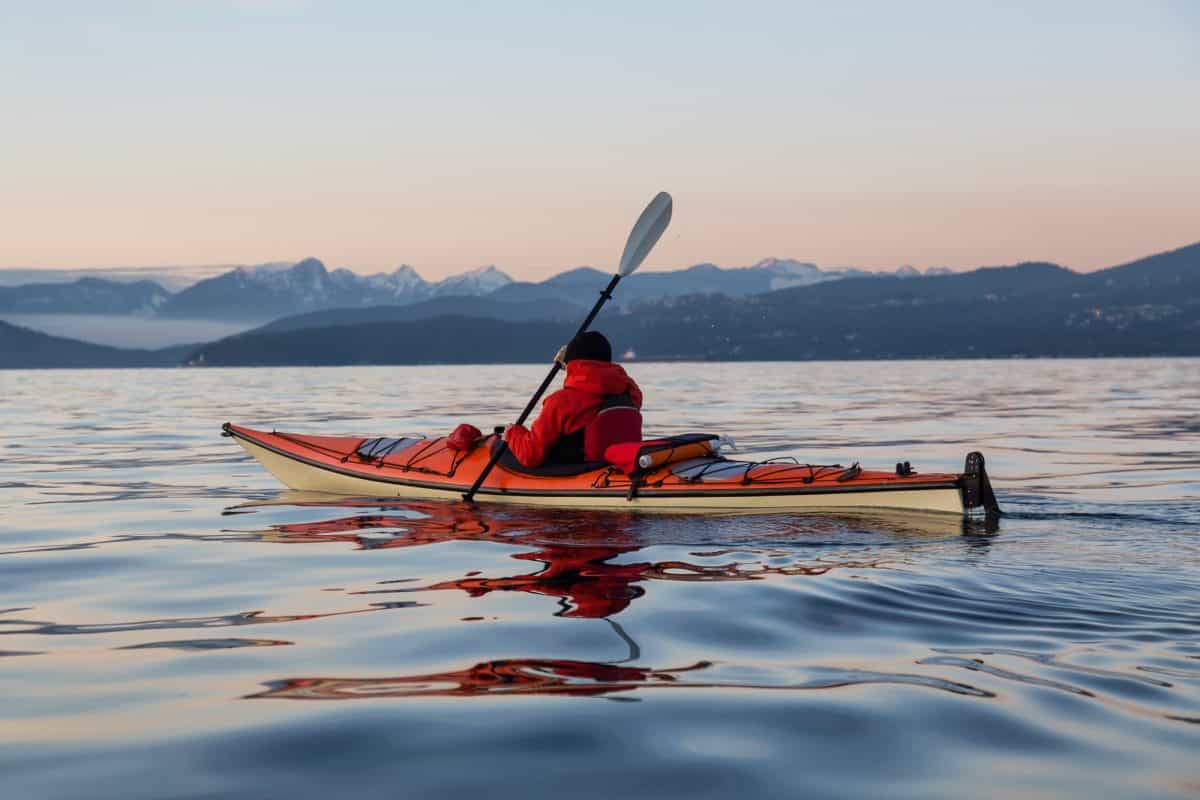 Man on a Sea Kayak paddling on the sea during winter
