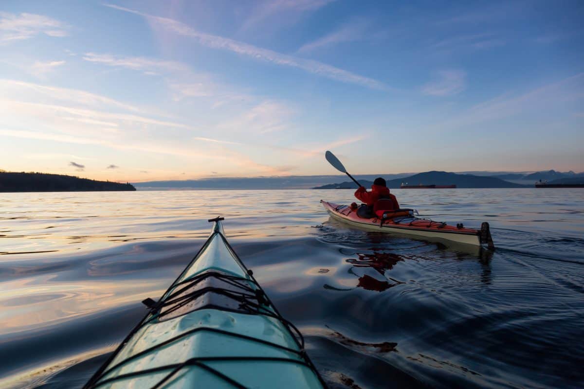 Two day touring kayaks on the open water at sunset