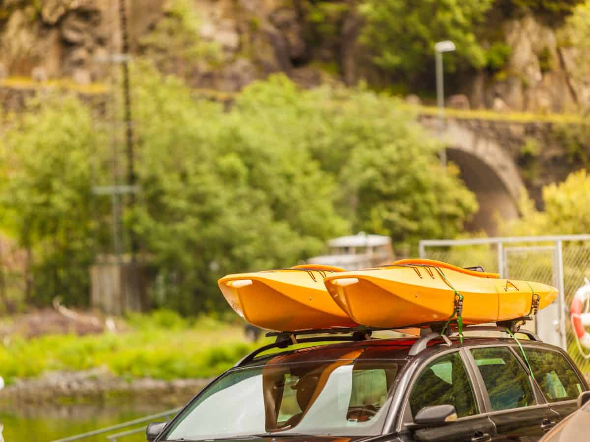 Two yellow kayaks strapped to a car roof rack