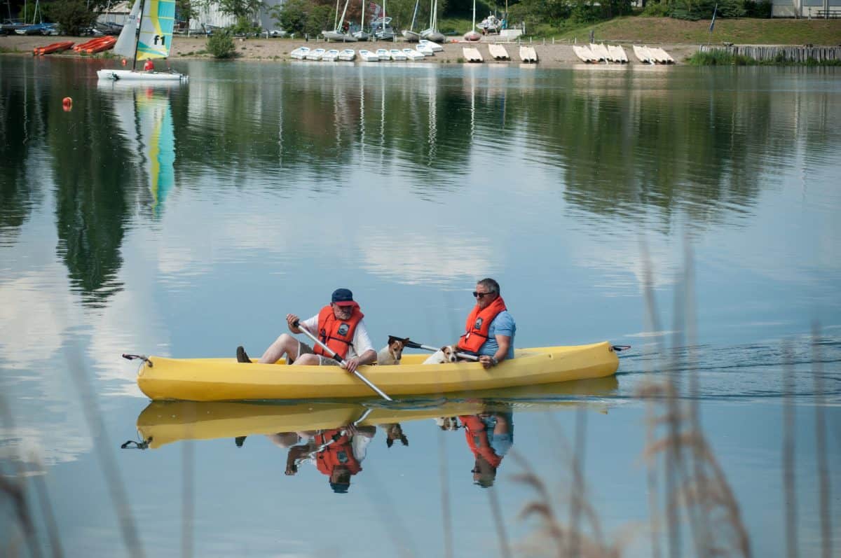 two old men and dogs in yellow kayak