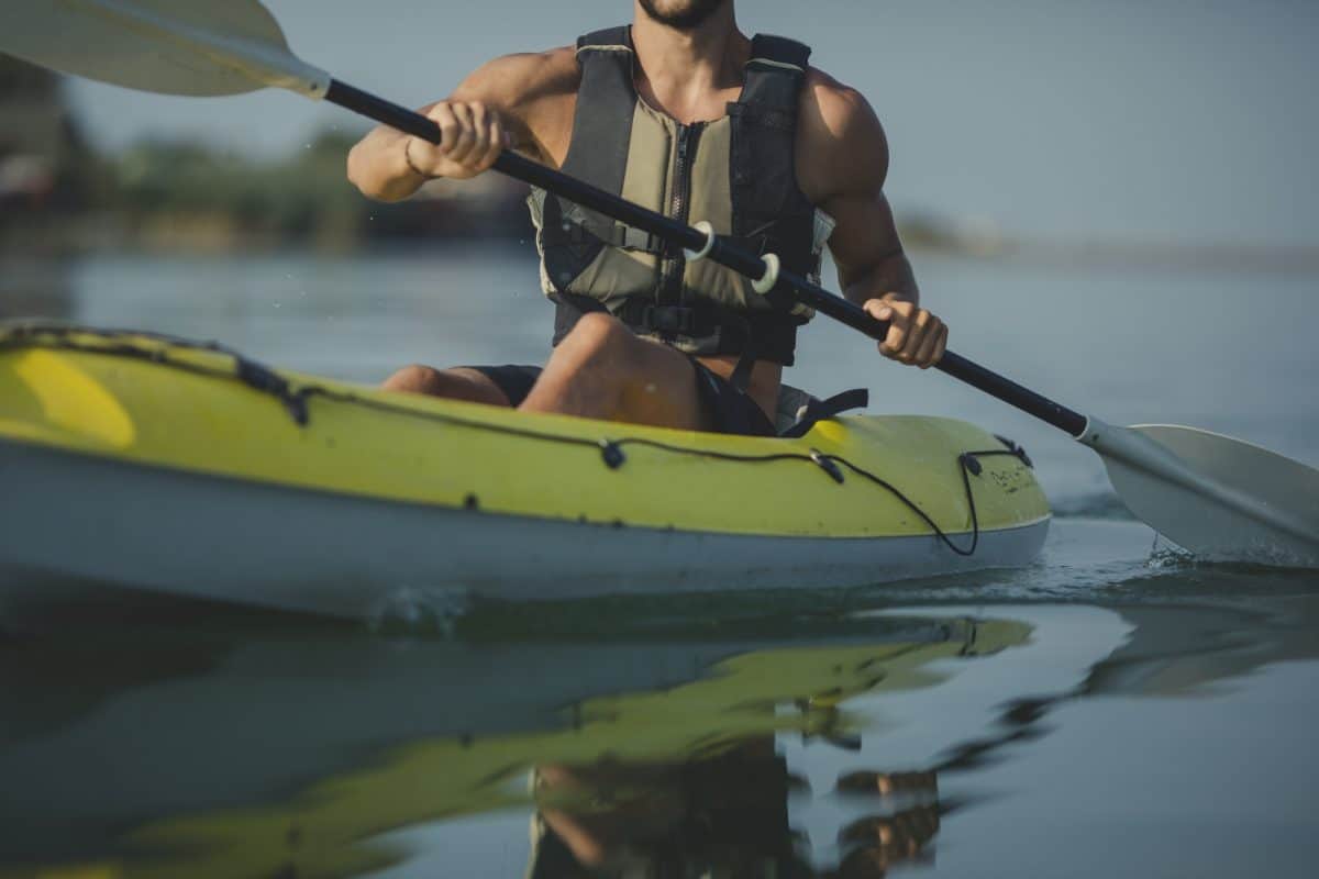 Caucasian man kayaker paddling on the river in life jacket