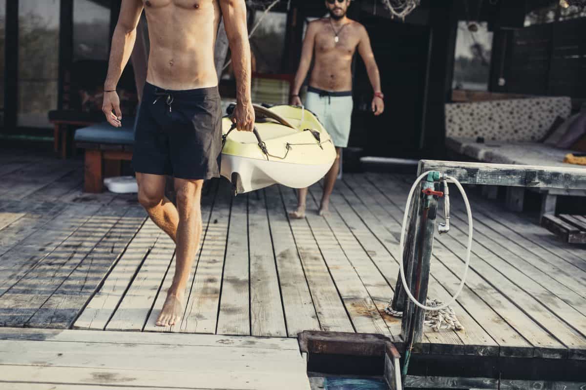 Kayak weight - how much does a kayak weigh.
Men carrying a kayak on wooden deck.