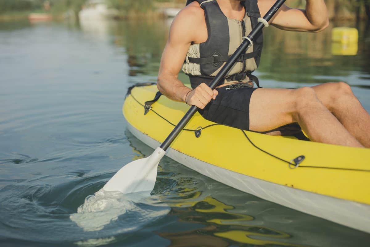 Unrecognisable man wearing life vest kayaking