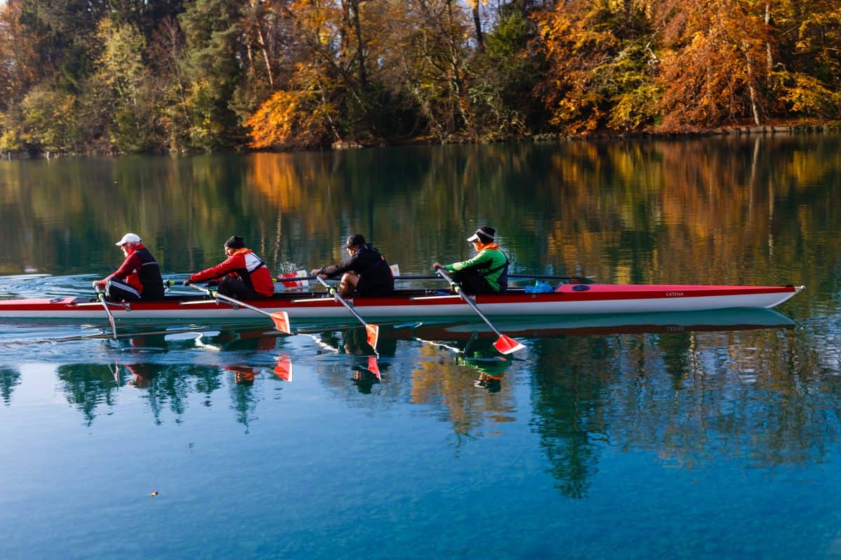 oar vs paddle - 4 rowers on calm winter river