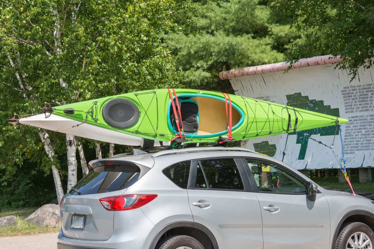 Kayak on kayak roof rack system, tired down with straps, bow and stern lines