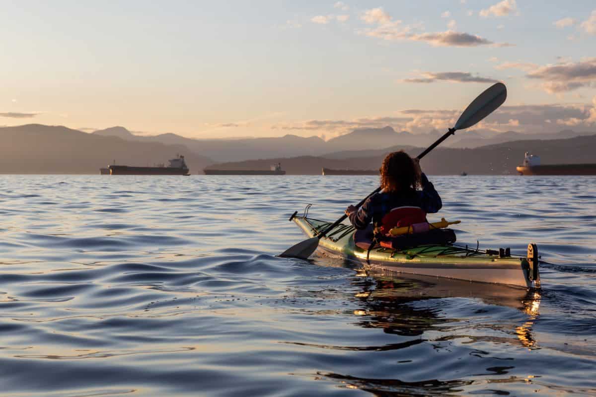 Girl Sea Kayaking during a vibrant sunny summer evening