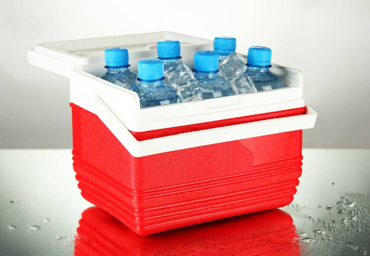 Kayak Cooler with bottles of water and ice cubes, on grey background