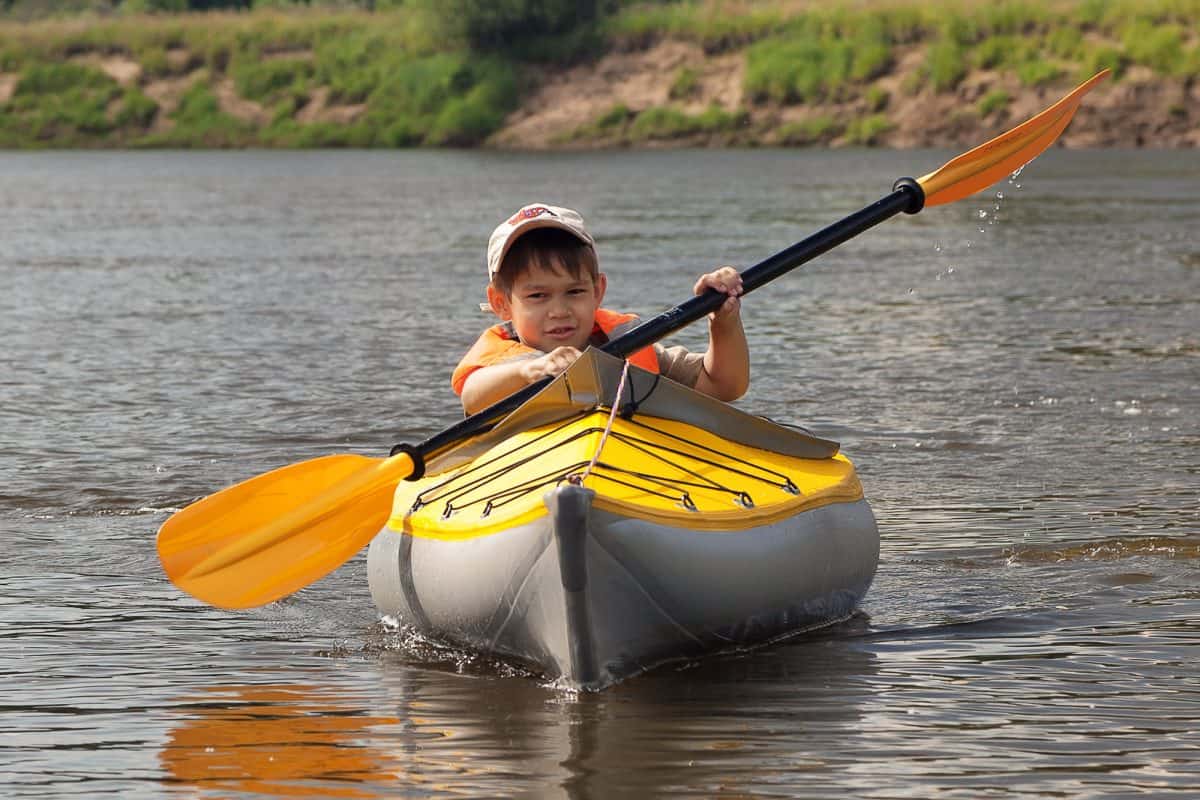 young child solo kayaking in kids kayaks