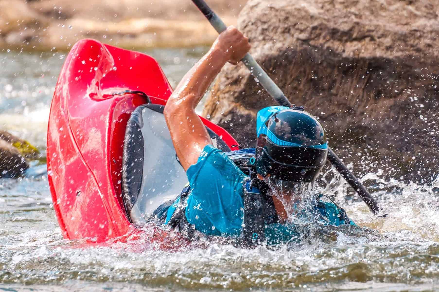 whitewater kayaker rolling a kayak