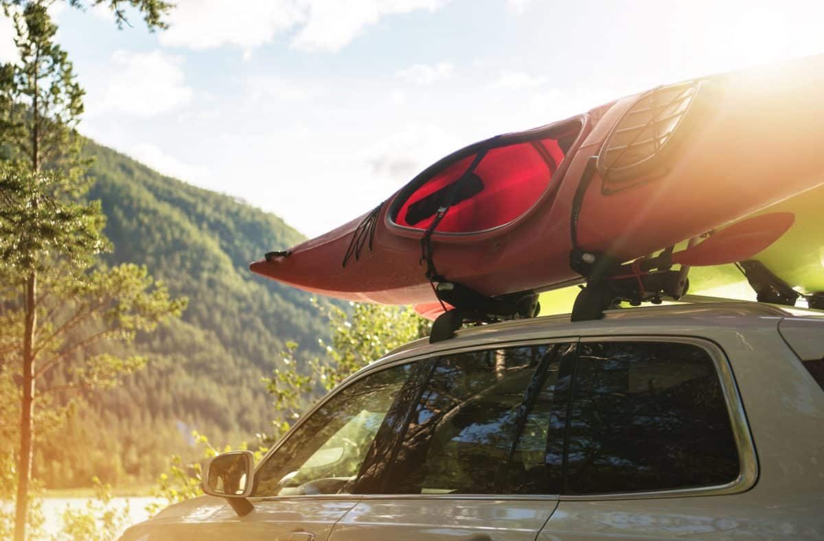 Car with red kayak on  j-cradles roof rack
