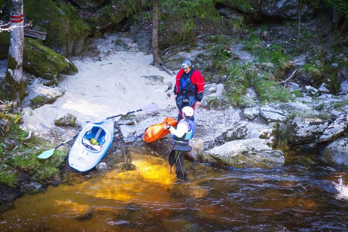 Man and women on river bank, portering around river hazards