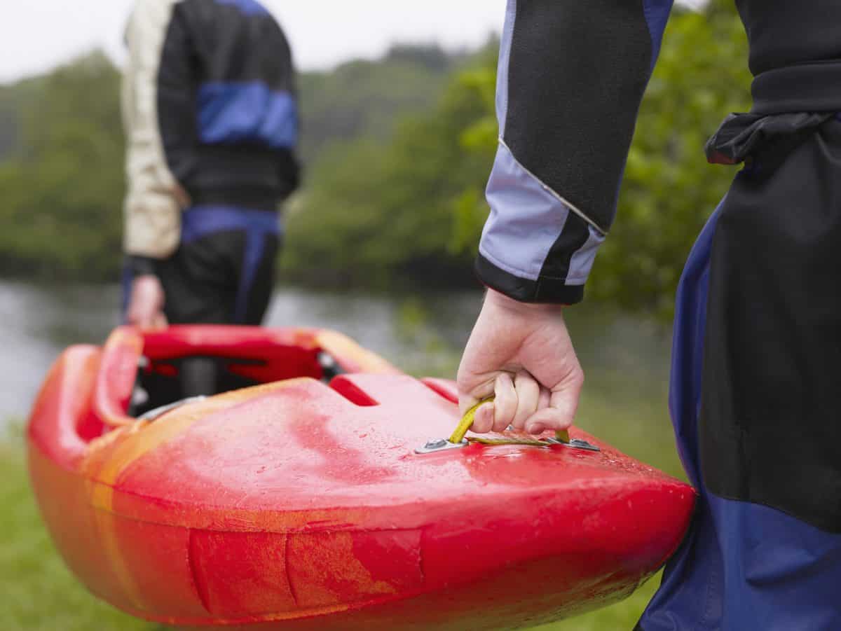 two men carry a kayak
