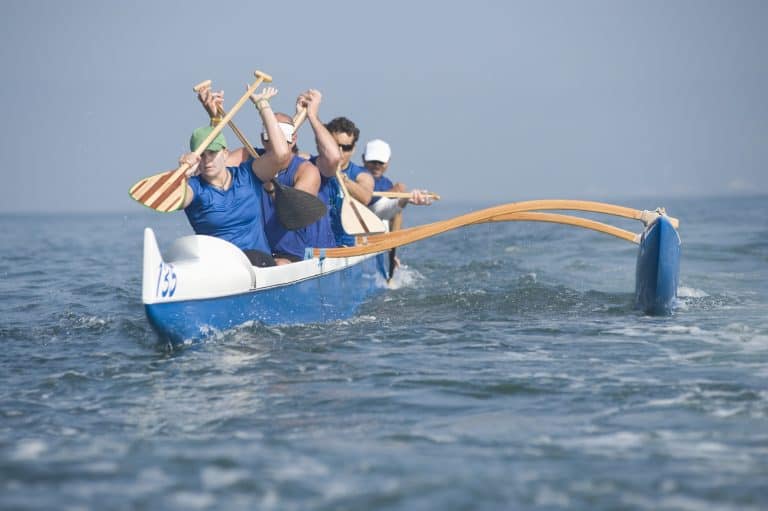 Kayaker in race canoe with outriggers and stabilizers