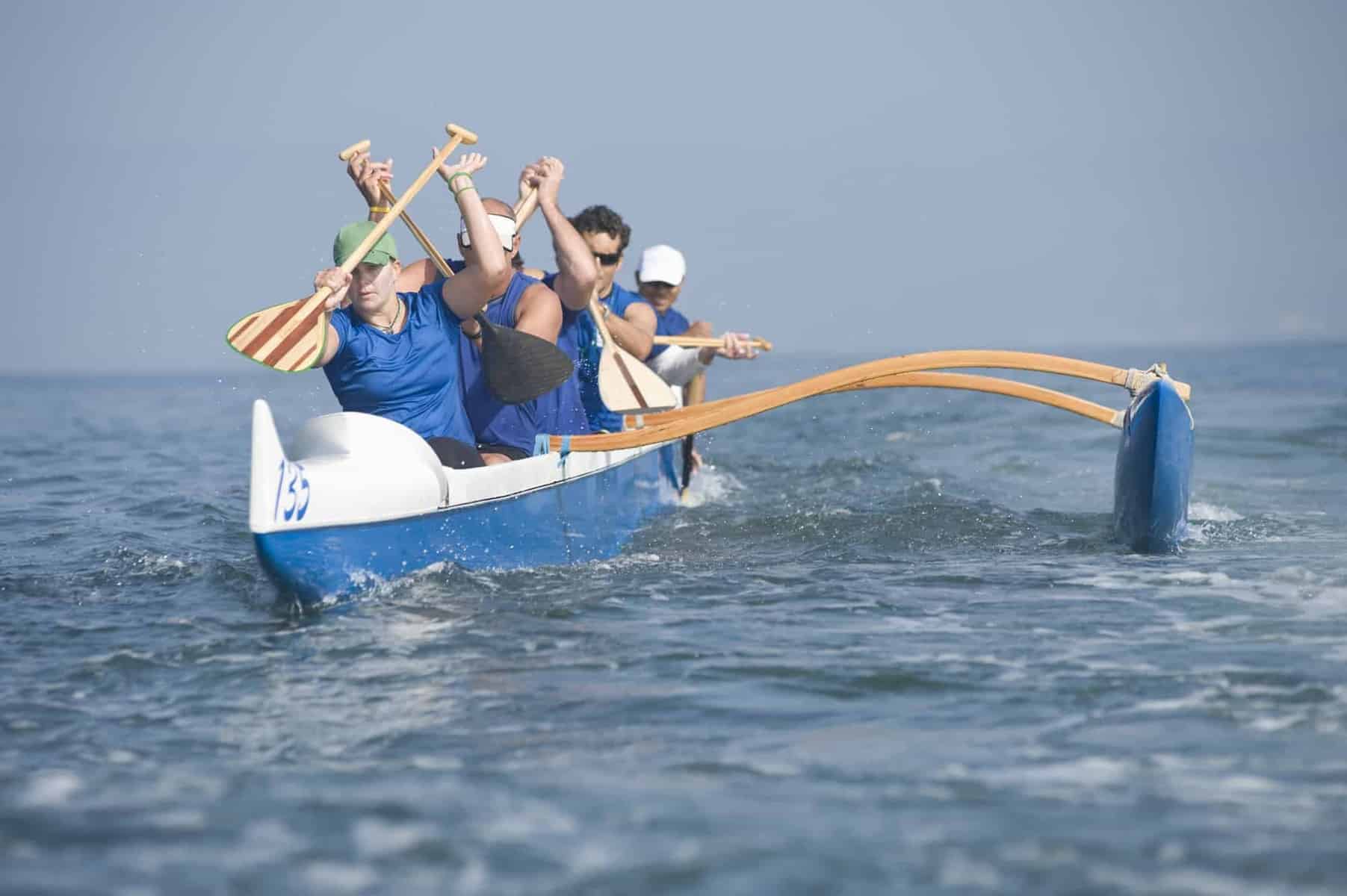Kayaker in race canoe with outriggers and stabilizers