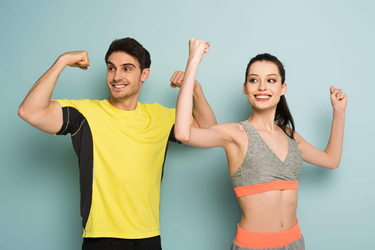 Man and woman showing muscles wearing sports tops