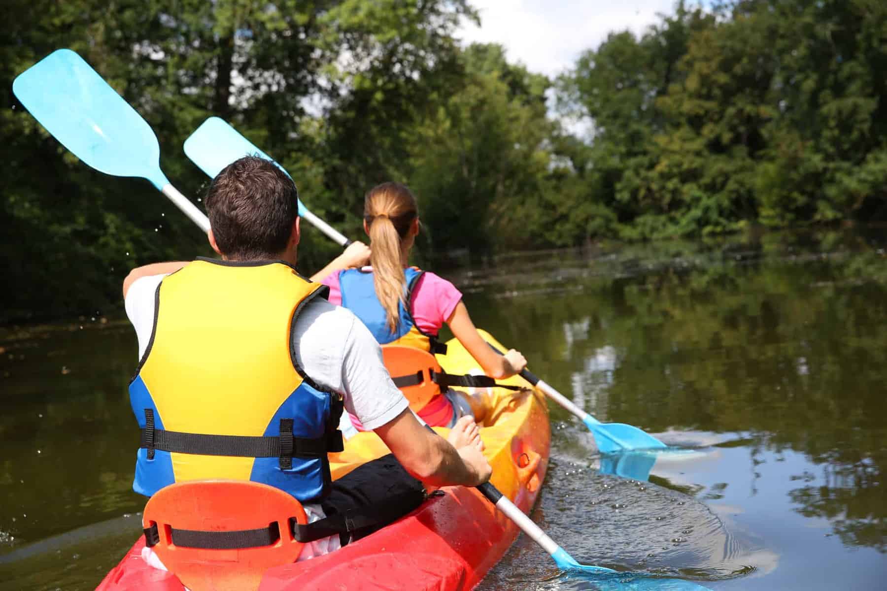 Couple paddling kayak in river