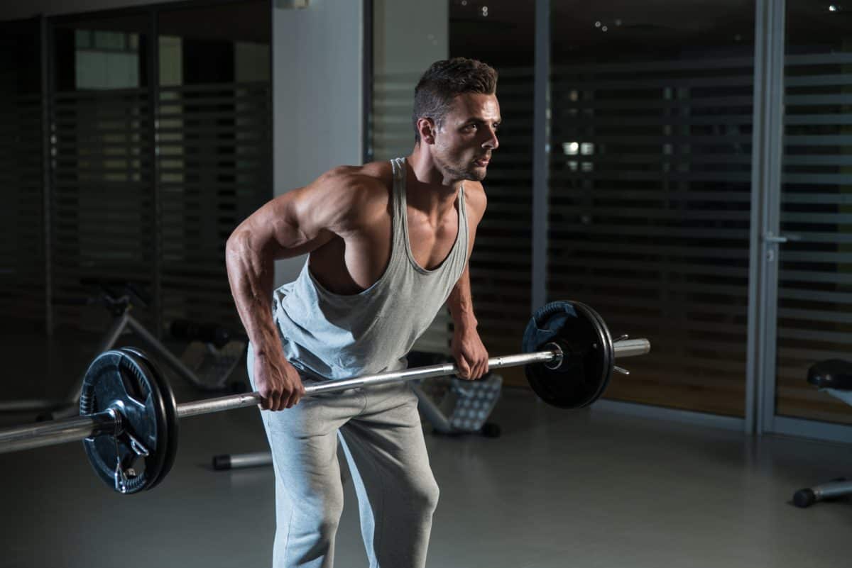 Man Doing bend over row Exercise For Back With Barbell