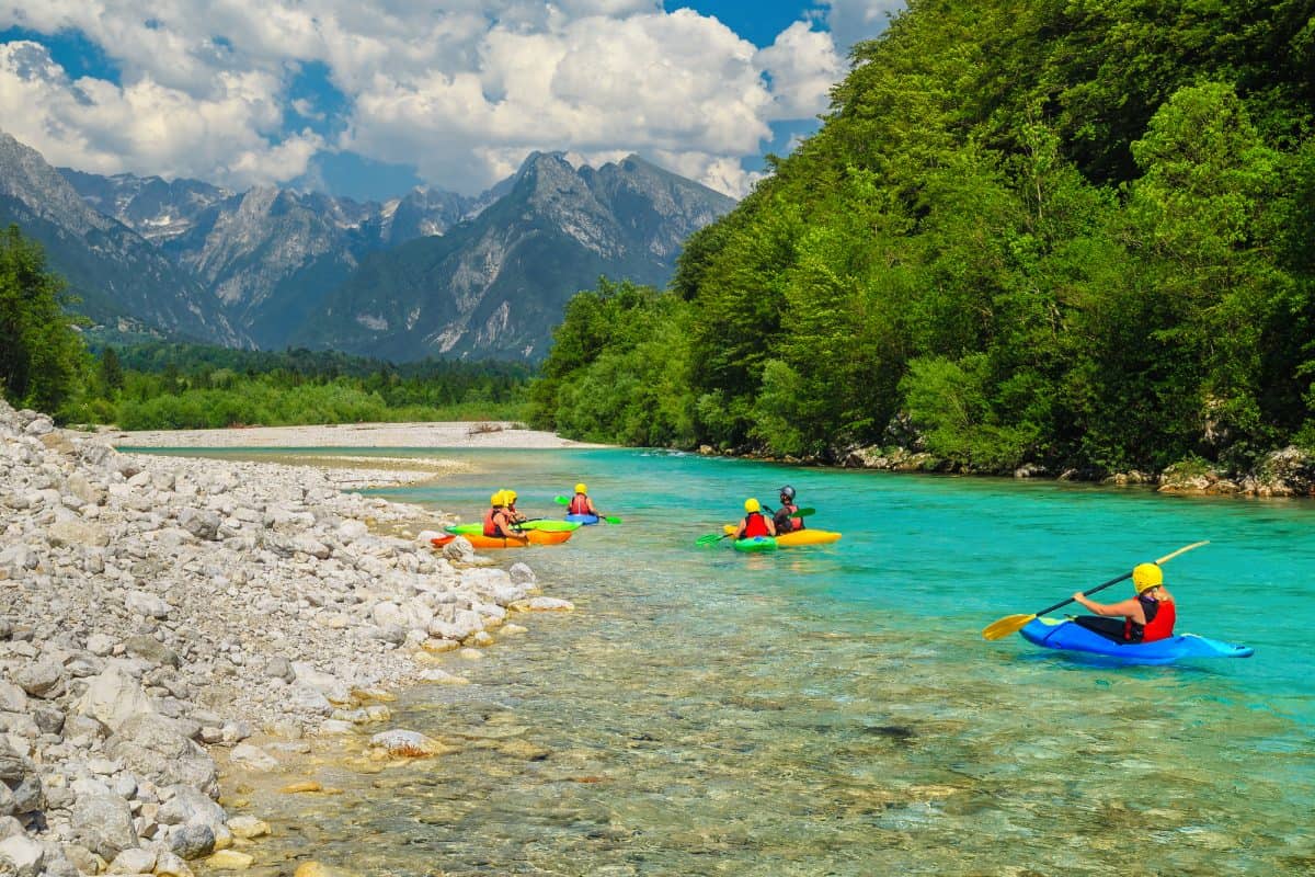 Group of 4 kaykers in yellow kayaks by river