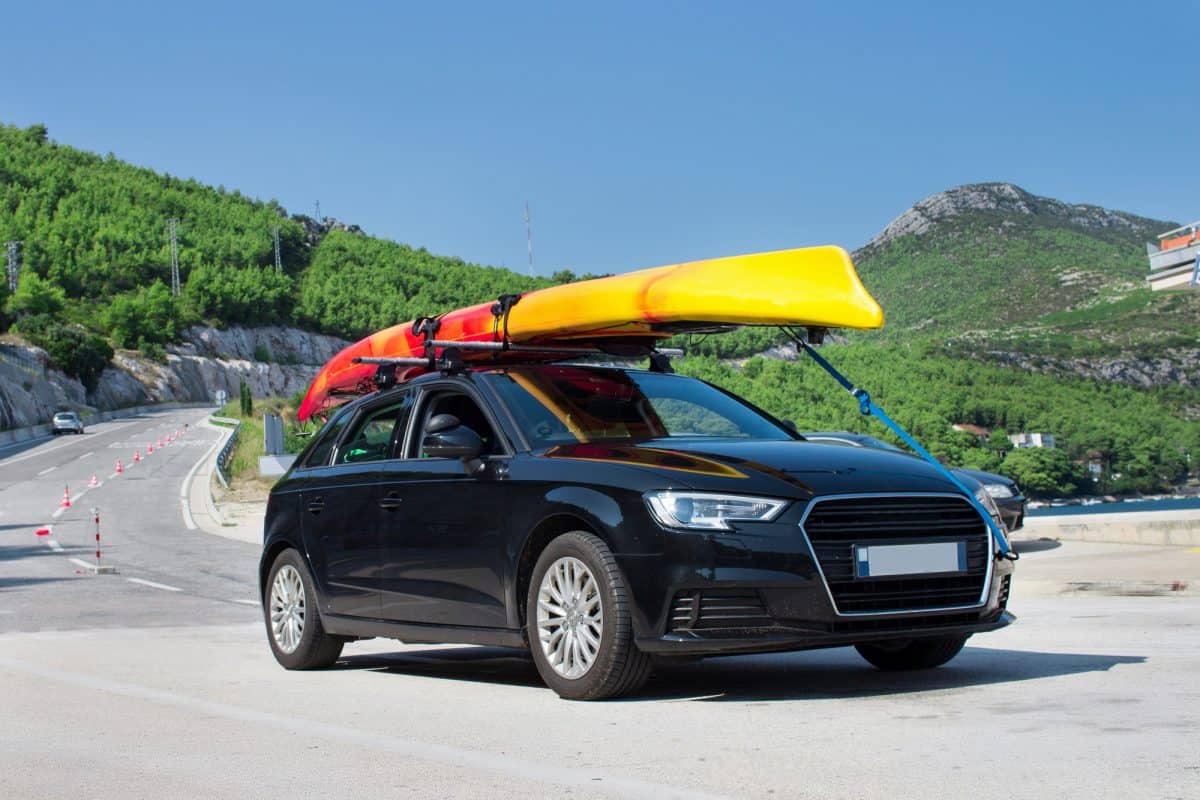 Kayak on roof rack of black audi cr