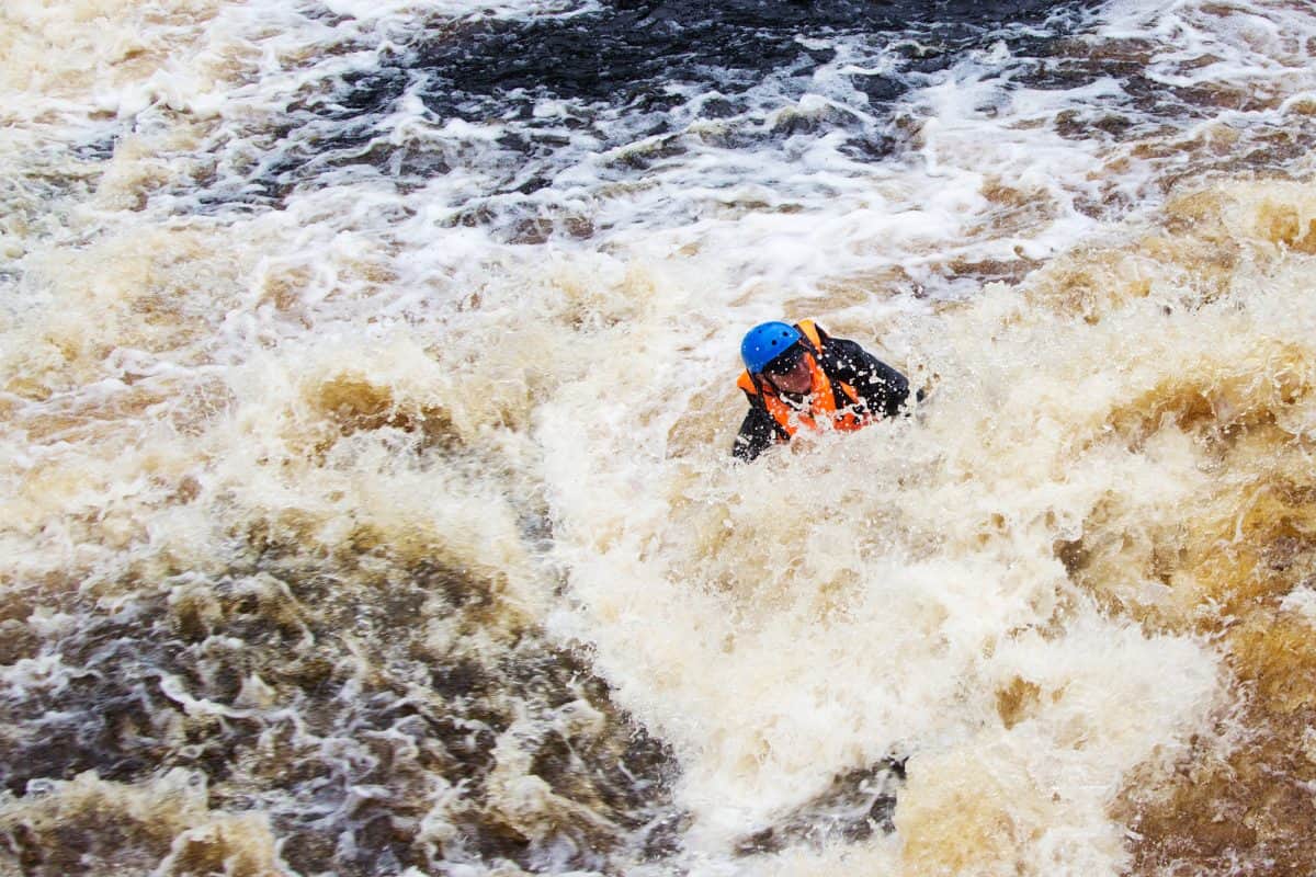 Person in life jackets drowning in a turbulent river