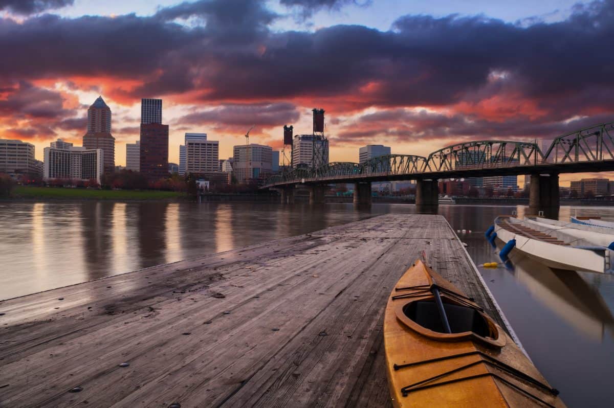 Kayaking at night. Portland, Oregon Panorama.  Sunset scene with dramatic sky and light reflections on the Willamette River.