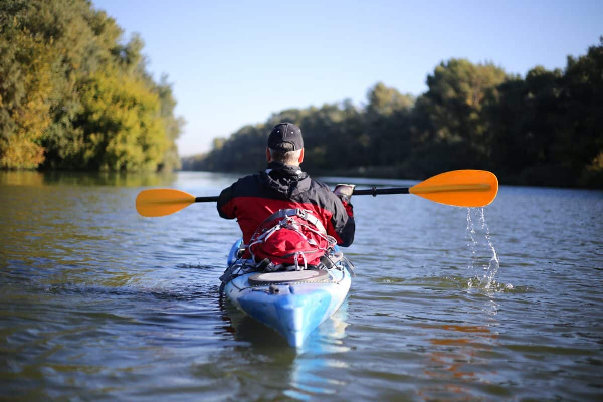 shot from behind of man in Sit-in kayak