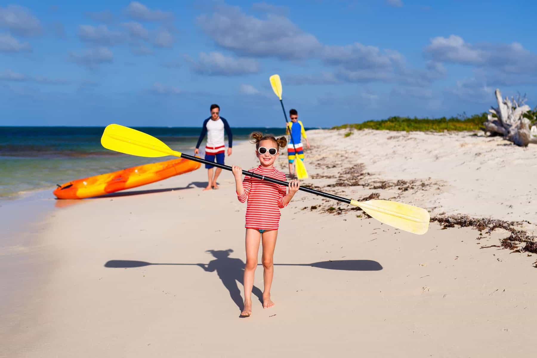 Family father and kids on their way to paddle a kayak