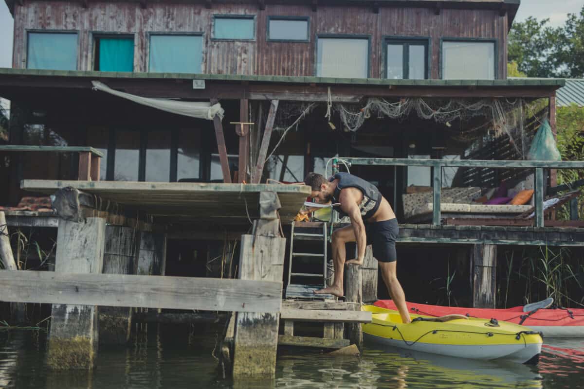 Man Getting out of a kayak from a dock side