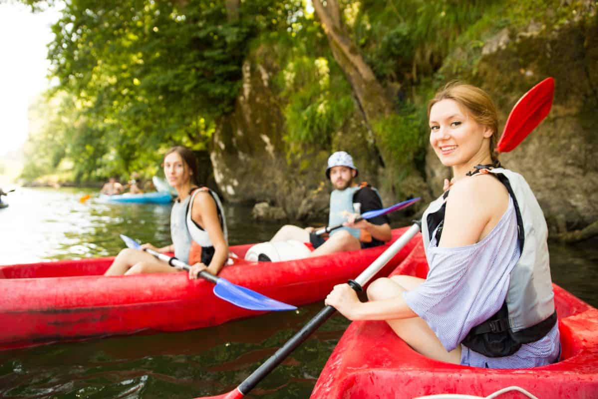 Group of friends on the river in bright red kayaks