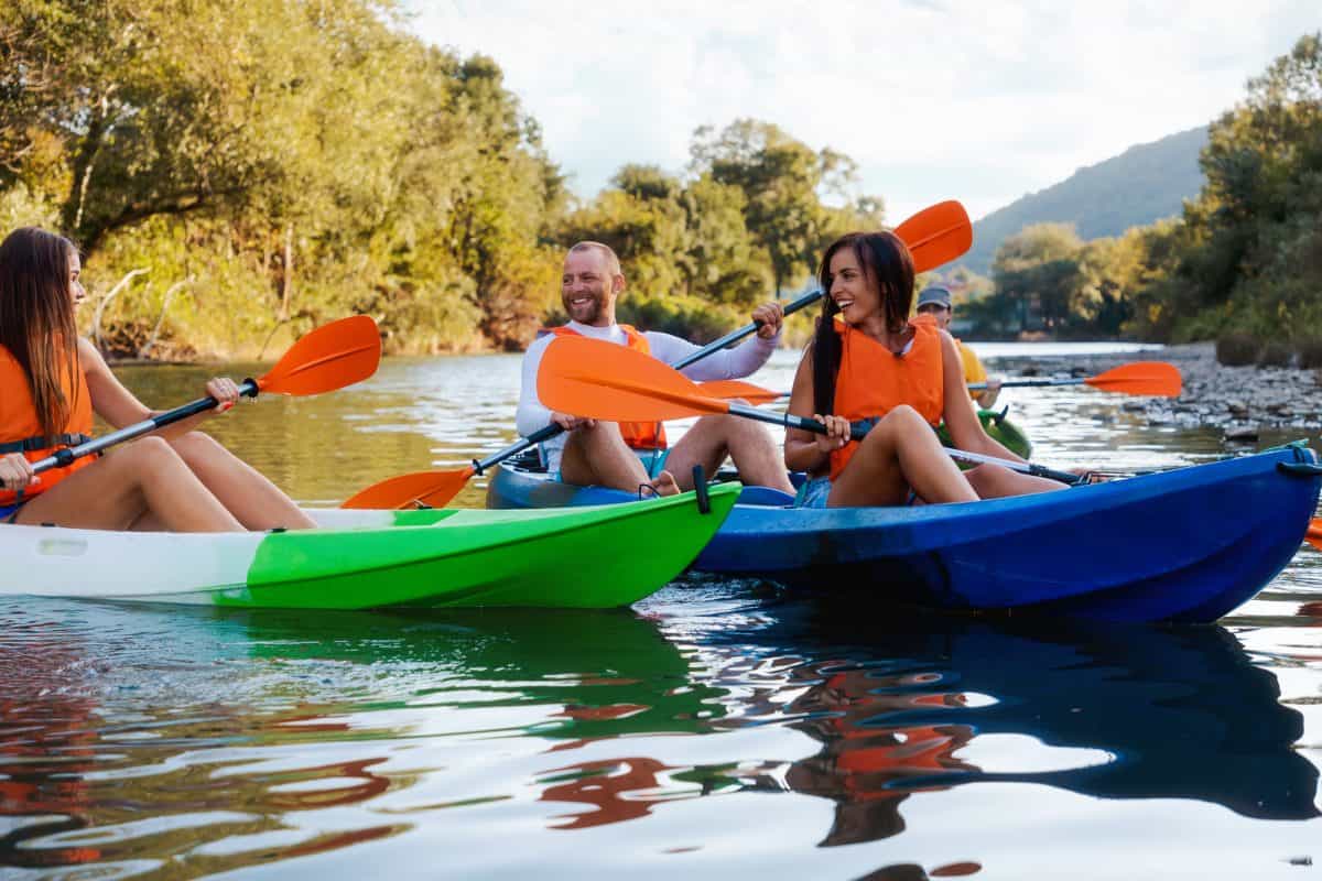 Group of people on the river in colorful Sit On Top Kayaks