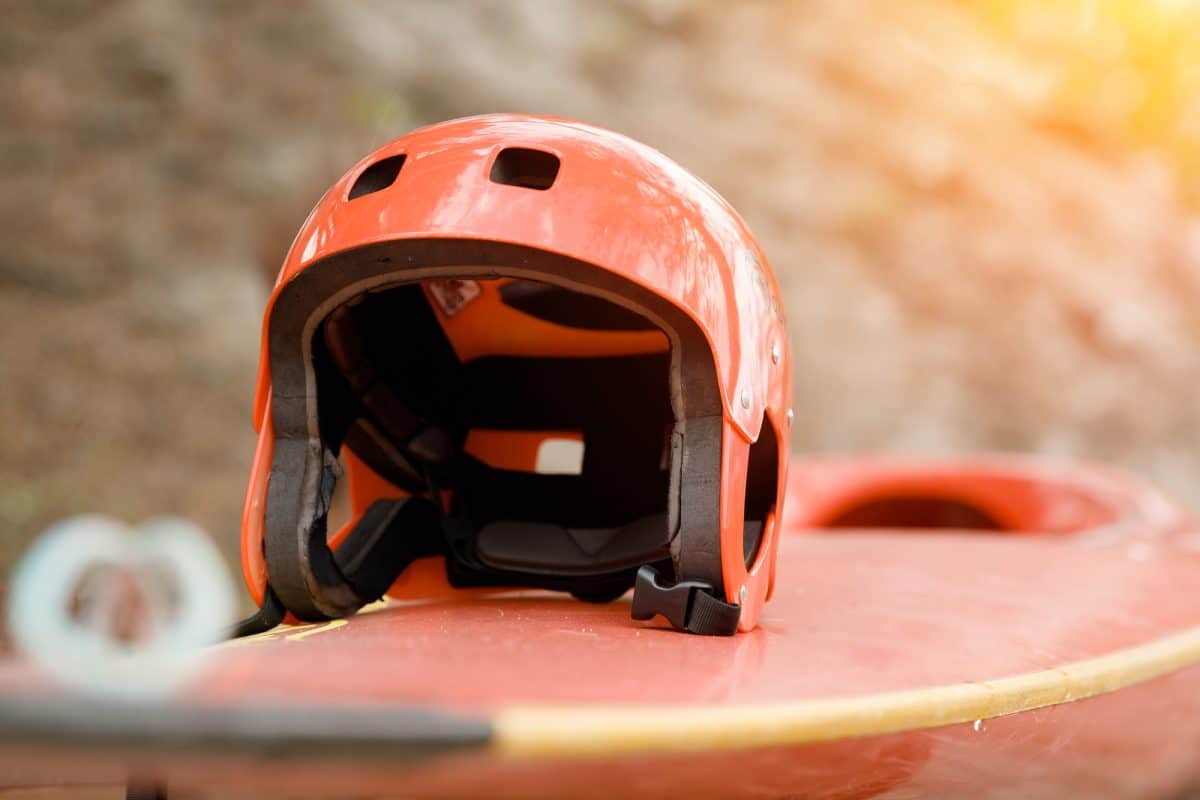 Red water sports helmet sitting on a kayak