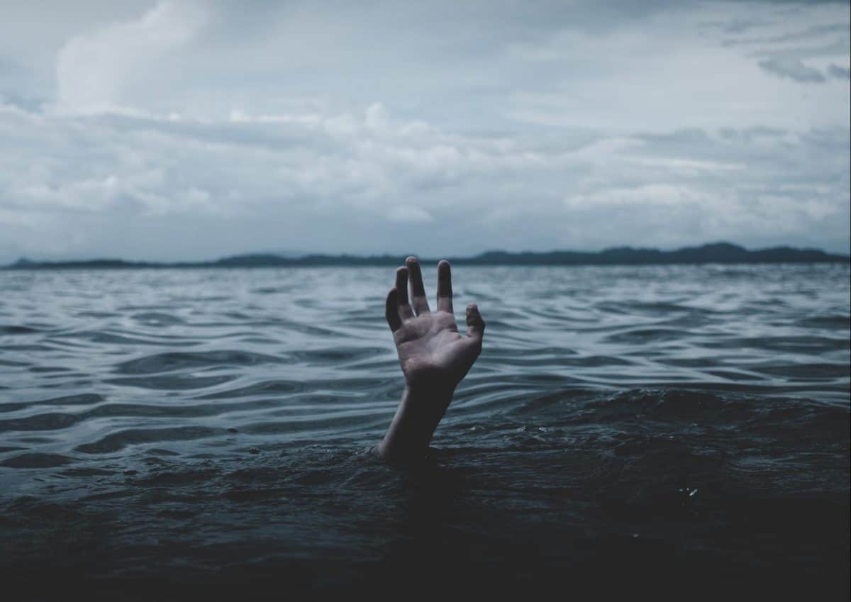 Hand coming up from underwater at night