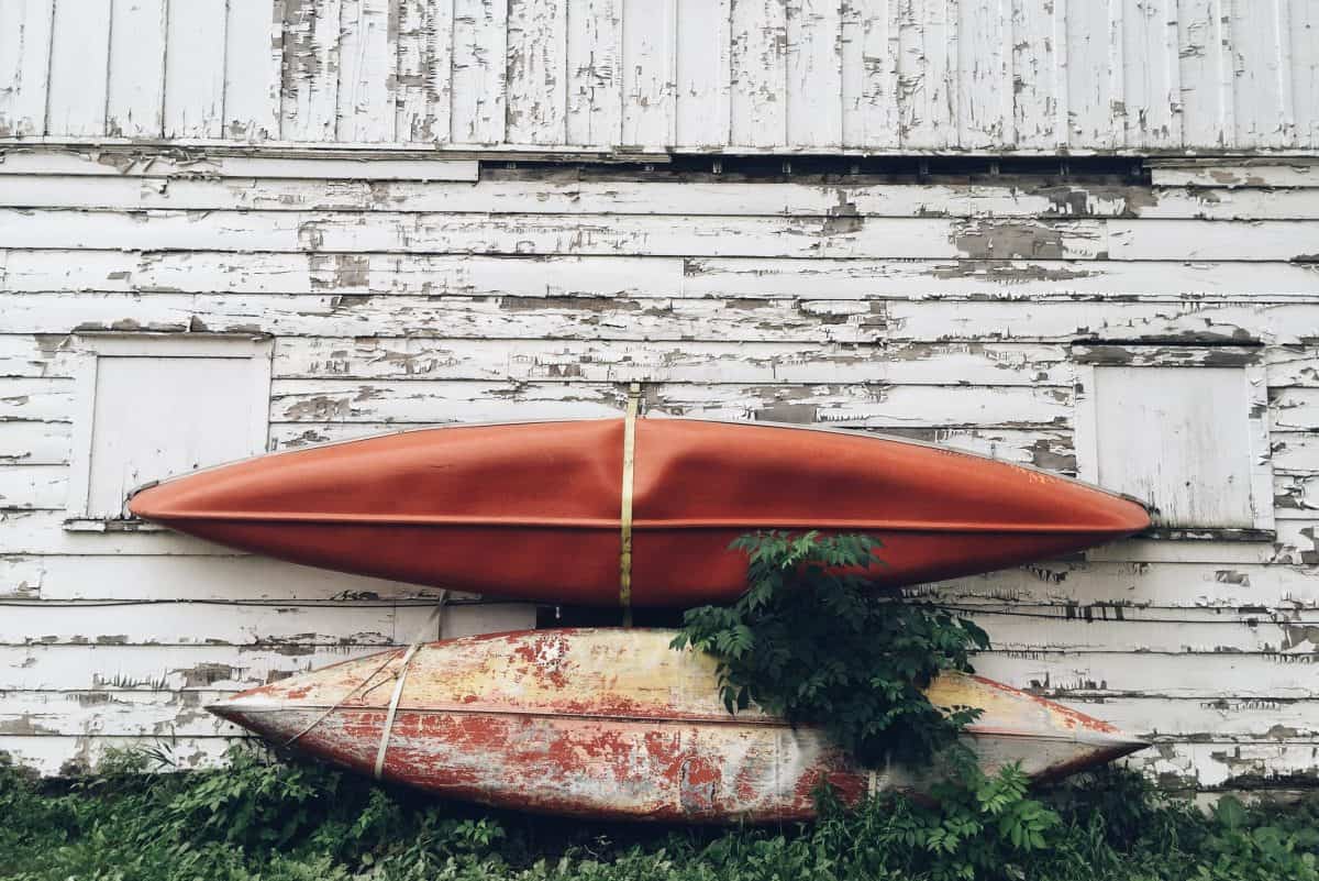 Two Old kayaks being stored hanging from wall