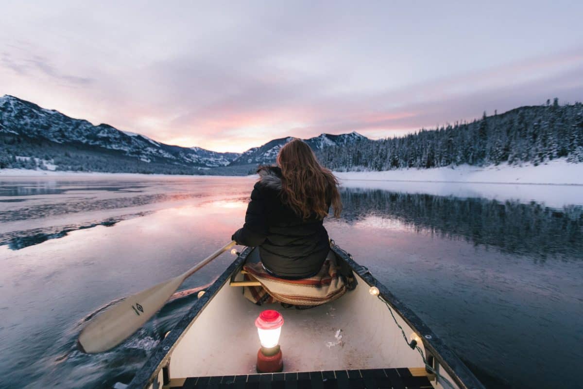 women in canoe kayking at night with light 