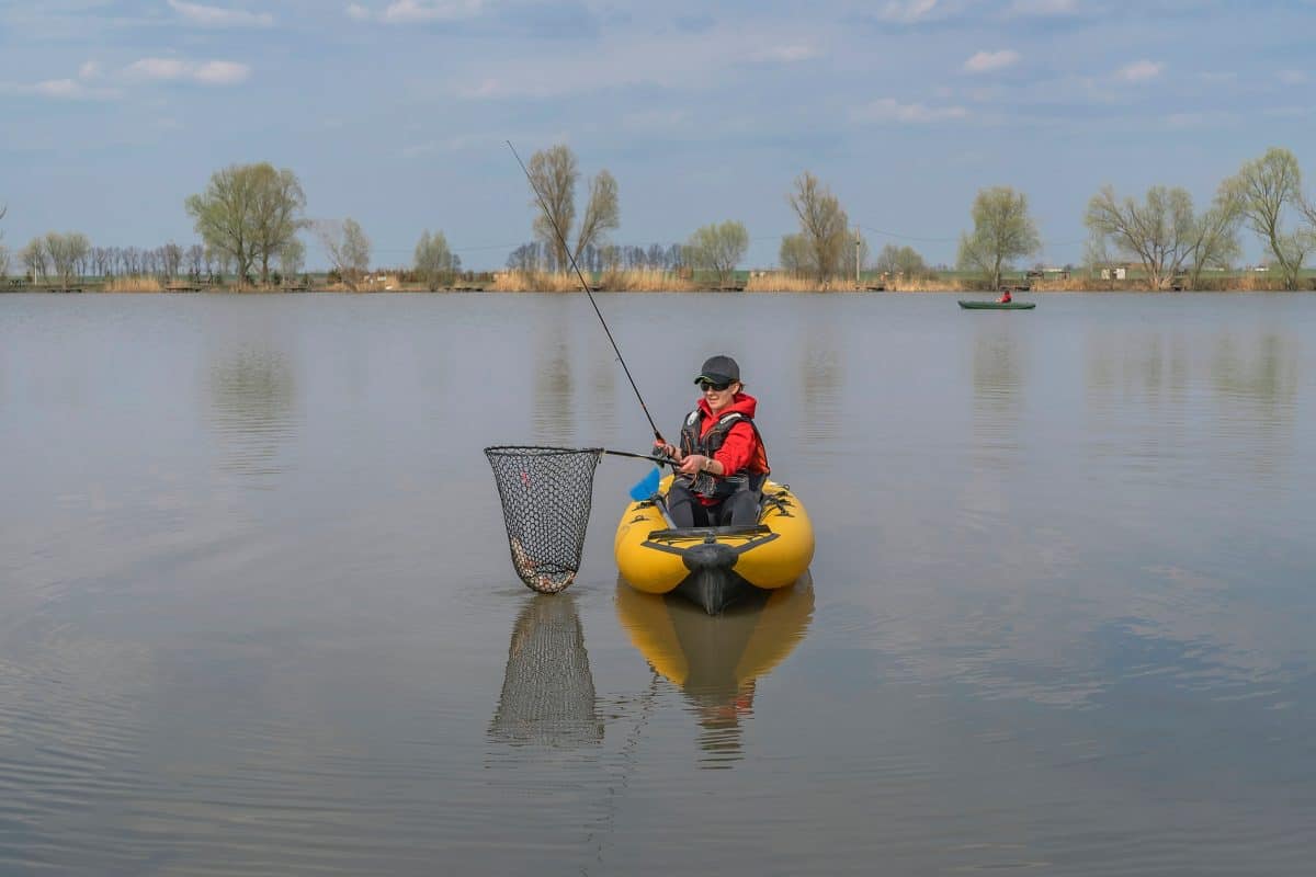 Kayak angler landing fish whilst out on the water