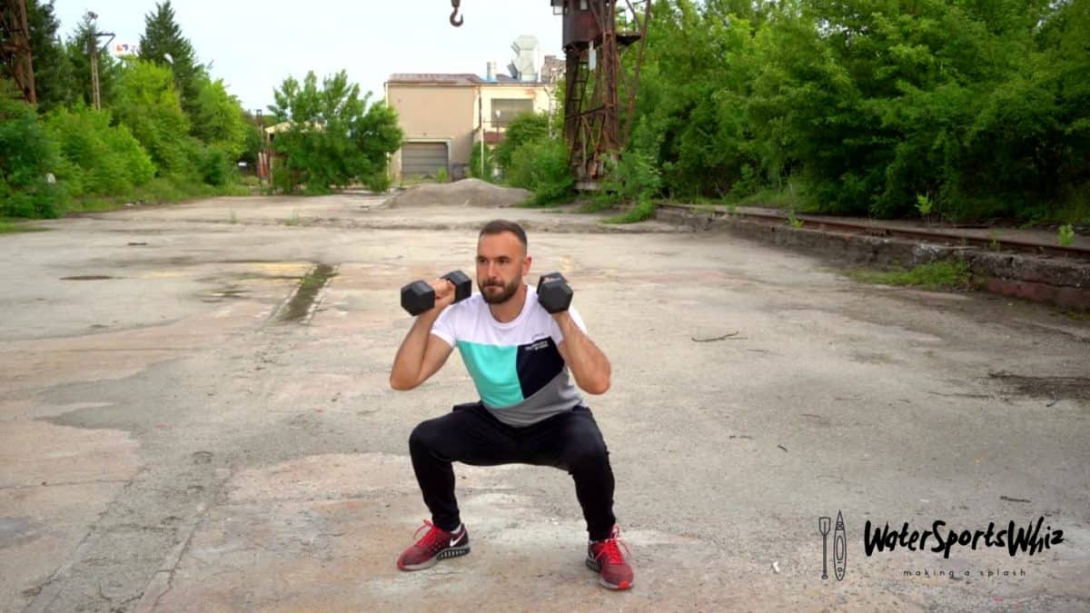 Man performing a dumbbell squat and press