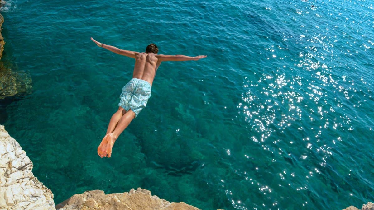 Man cliff diving into sea