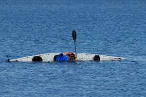 Man in kayak about to roll and wet exit