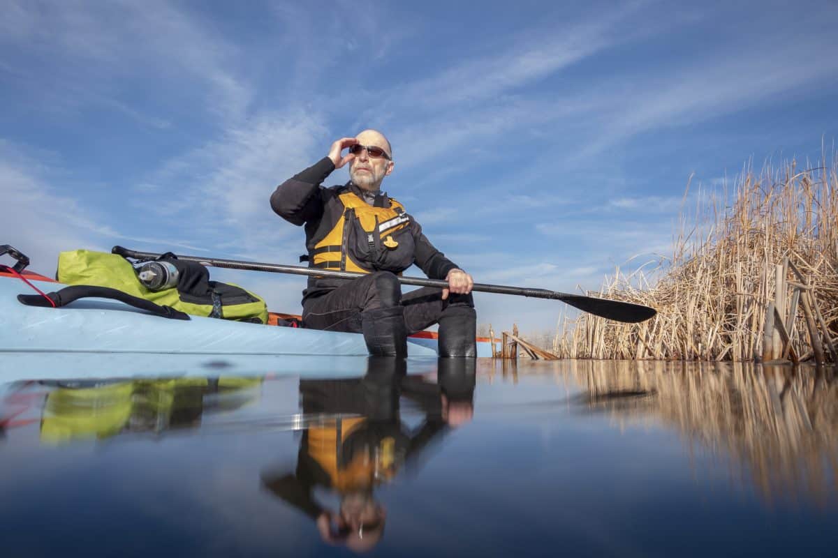 Man in wetsuit relaxing on kayak