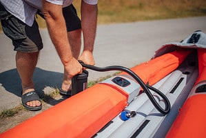 Man inflating an inflatable kayak