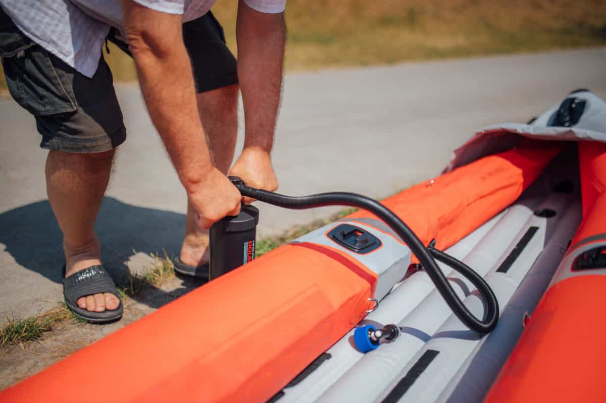 Man inflating an inflatable kayak