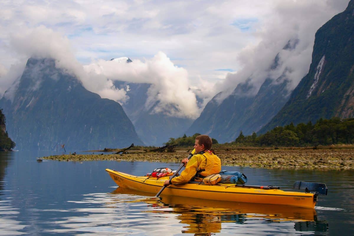 Man sea kayaking with mountain backdrop
