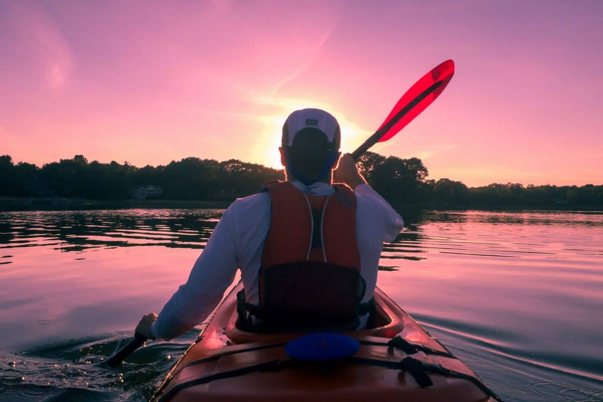 Kayaker paddling at sunset