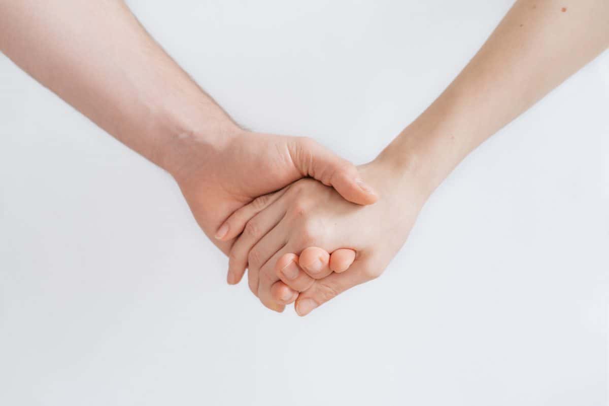 Two hands holding on white background