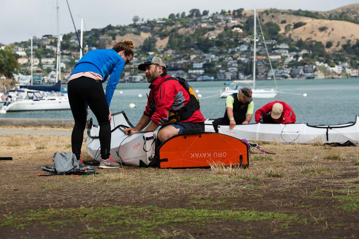 Assembling Oru kayak on river bank
